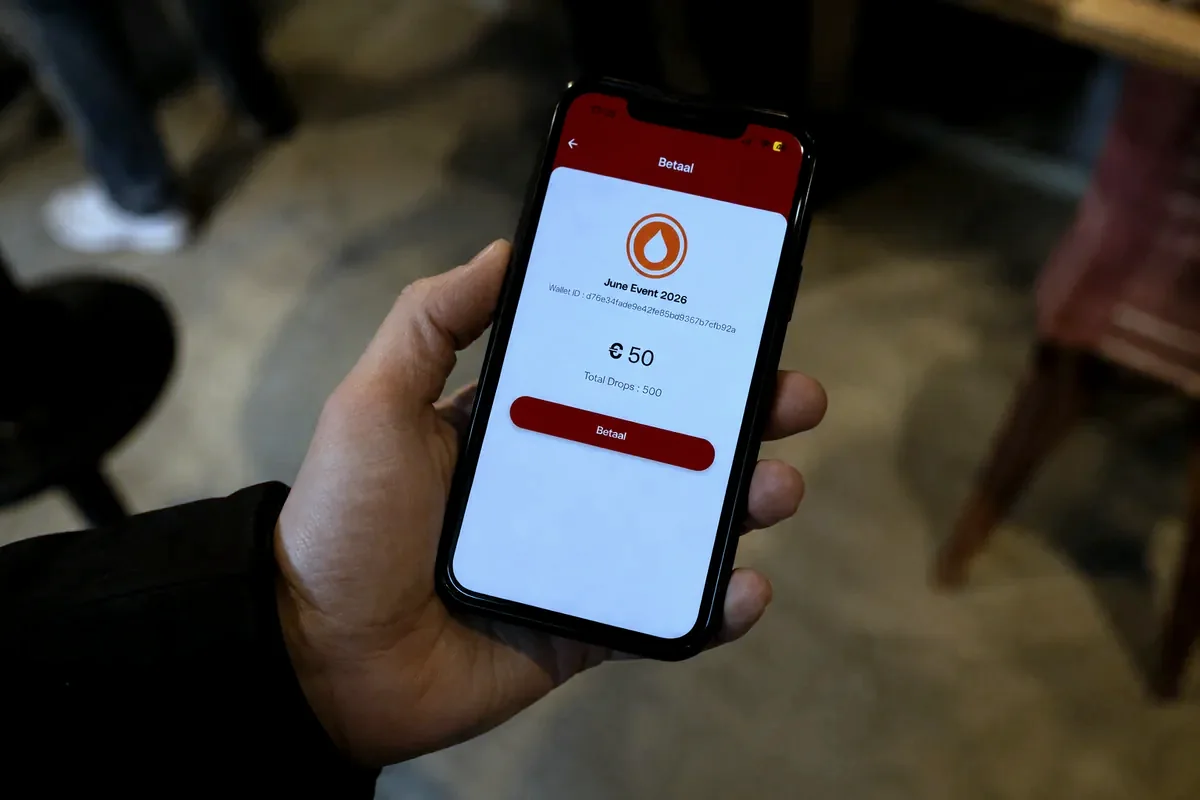Een bezoeker houdt de telefoon vast met het tegoed in de Drop-app, klaar om te betalen