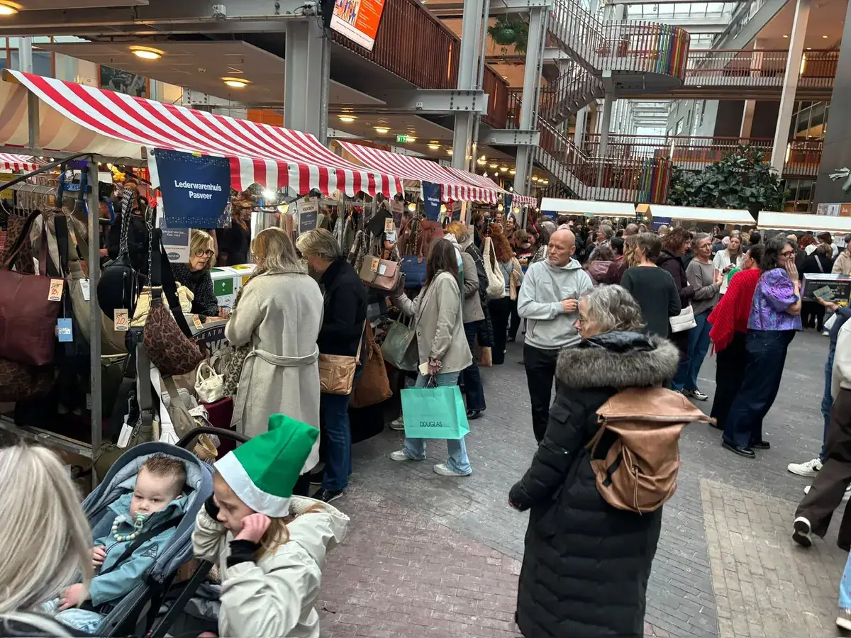Bezoekers lopen langs de kramen van een markt